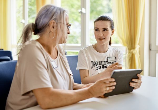 Praxisanleiterin und Schülerin sprechen über etwas am Tablet