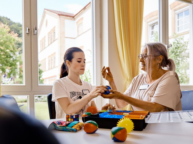 Praxisanleiterin erklärt einer Praktikantin eine Skills-Box